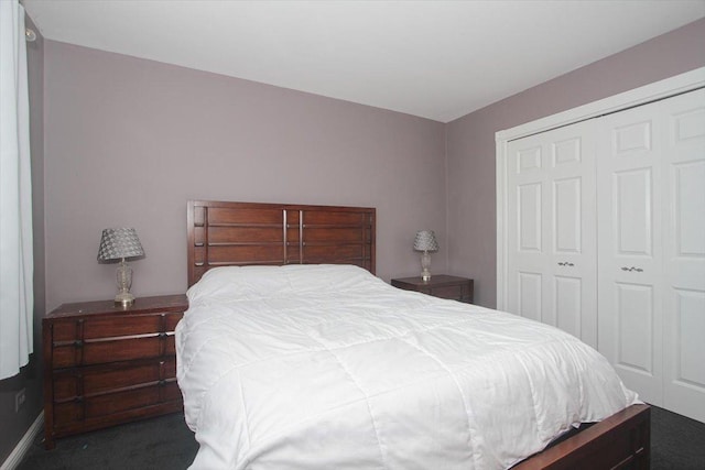 bedroom with dark carpet and a closet