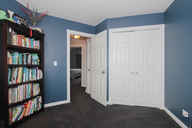 unfurnished bedroom with a closet and dark colored carpet