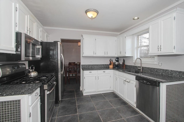 kitchen featuring sink, appliances with stainless steel finishes, ornamental molding, white cabinets, and dark tile patterned flooring