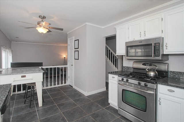 kitchen featuring dark stone countertops, dark tile patterned floors, white cabinets, and appliances with stainless steel finishes