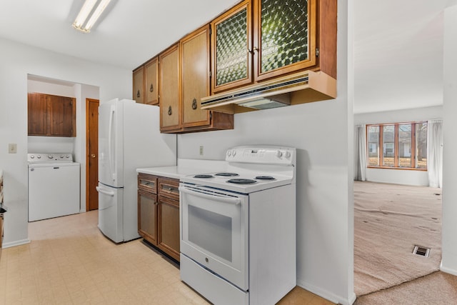 kitchen with under cabinet range hood, light floors, white appliances, light colored carpet, and washer / dryer