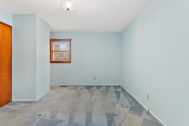 spare room featuring baseboards and carpet