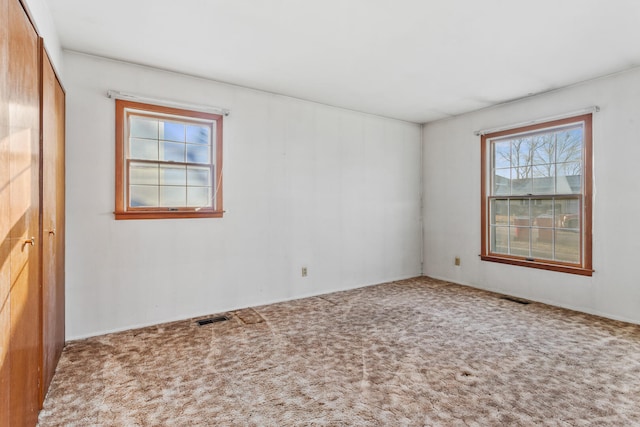 carpeted empty room with visible vents