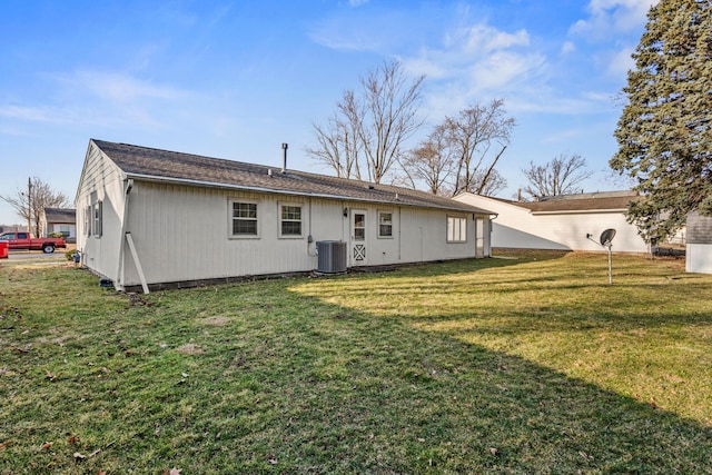 back of property with a yard and central AC