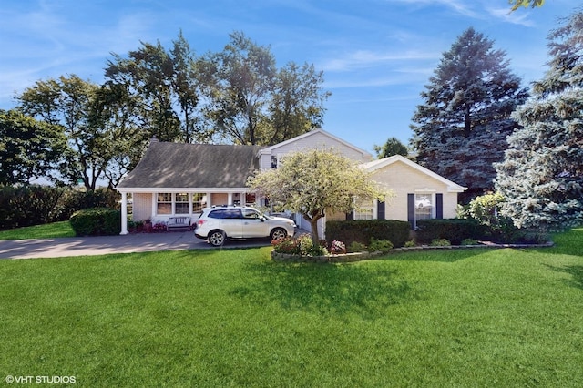 view of front of property with a front yard, brick siding, and driveway