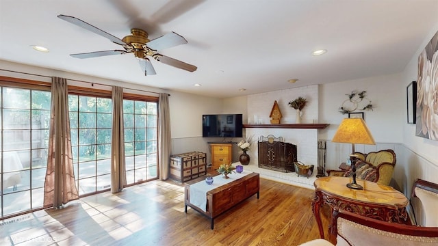 living area featuring wood finished floors, recessed lighting, and a fireplace
