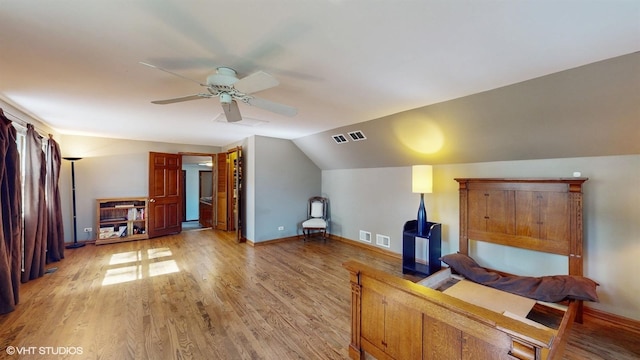 bedroom featuring visible vents, light wood-style flooring, baseboards, and vaulted ceiling