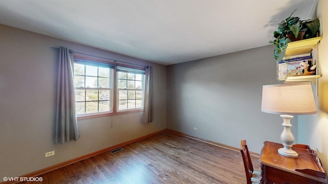 interior space with visible vents, baseboards, and wood finished floors