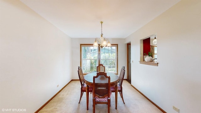 dining area featuring a notable chandelier, light colored carpet, and baseboards