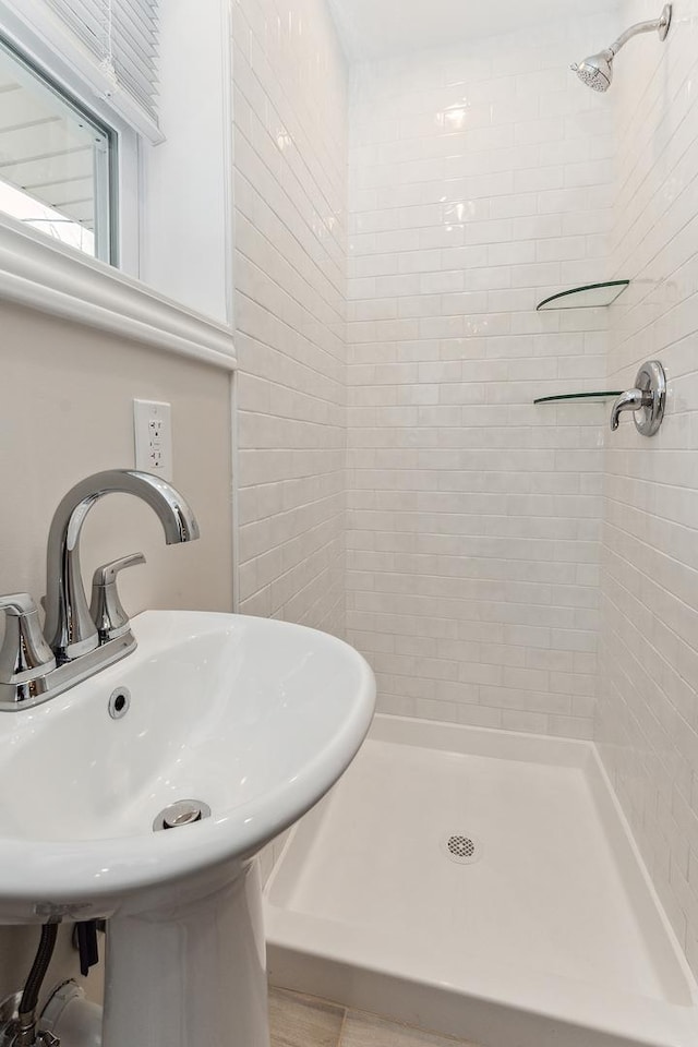 bathroom featuring a tile shower and sink