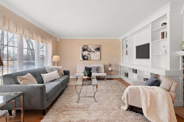 living room featuring crown molding, built in features, and hardwood / wood-style flooring