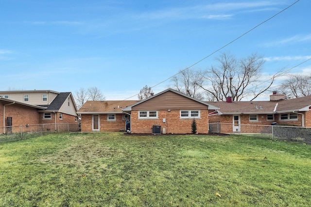 back of property featuring central AC unit and a yard