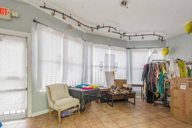 sunroom featuring rail lighting and plenty of natural light