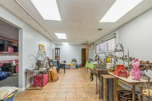 interior space featuring a paneled ceiling and light tile patterned floors