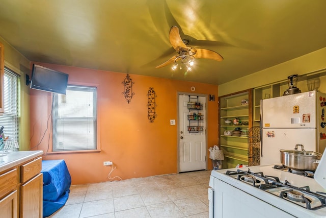 kitchen featuring light tile patterned floors, white appliances, and ceiling fan