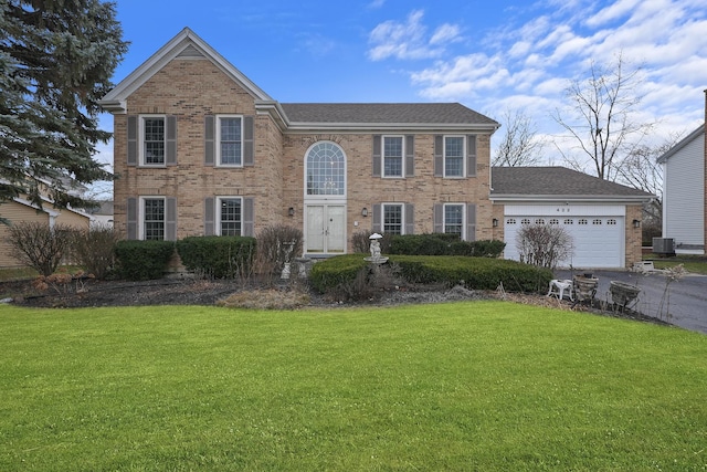 colonial home featuring a garage, a front lawn, and central air condition unit