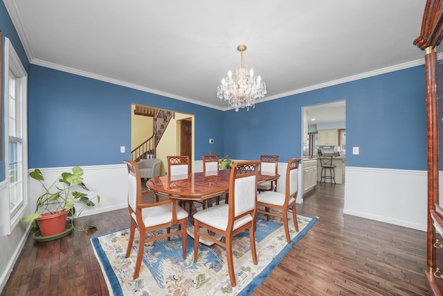 dining space featuring ornamental molding, a notable chandelier, and dark hardwood / wood-style flooring