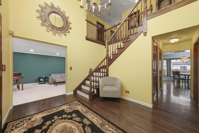 staircase featuring an inviting chandelier, wood-type flooring, and a high ceiling