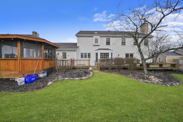 back of property featuring a sunroom and a lawn