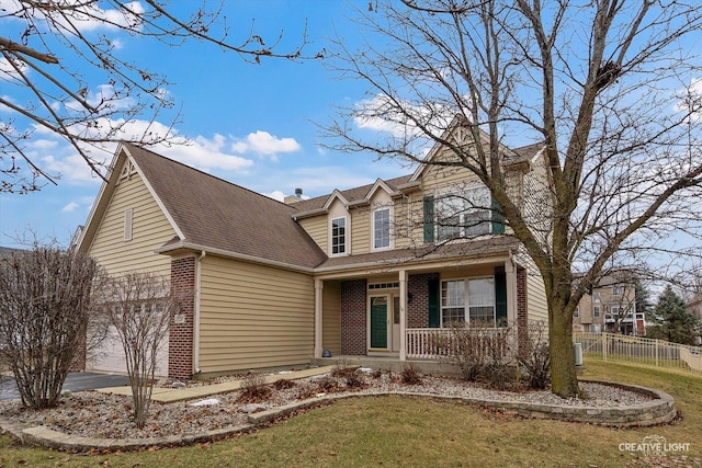 view of front of house featuring brick siding, covered porch, fence, a garage, and a front lawn