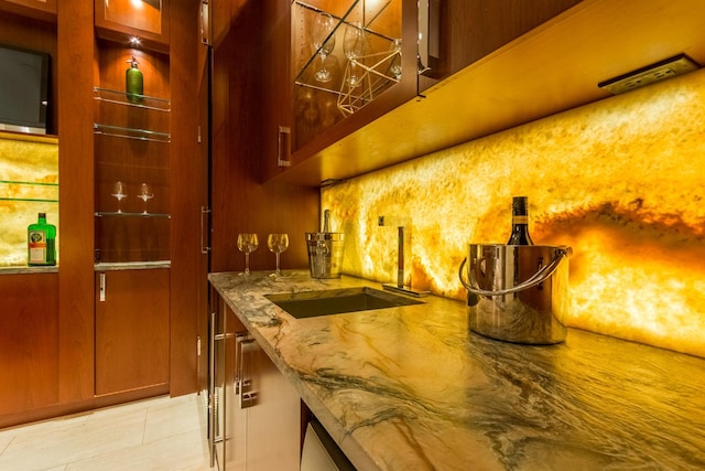 bar featuring light stone counters and sink