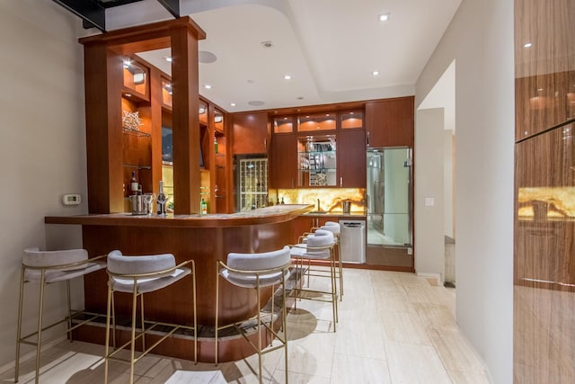 bar featuring fridge and tasteful backsplash