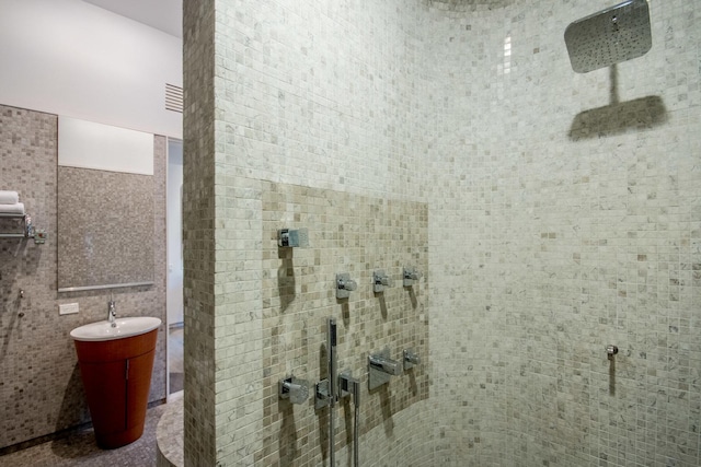 bathroom with tiled shower and tile walls