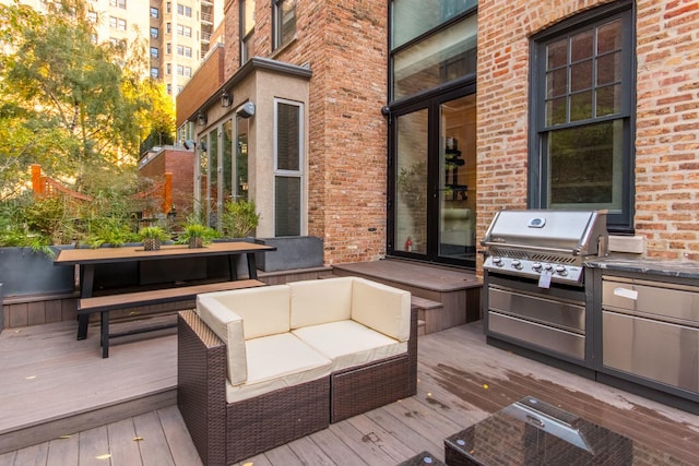 deck with an outdoor living space, exterior kitchen, and area for grilling