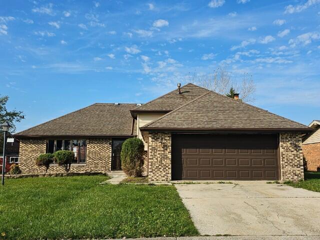 ranch-style house featuring a garage and a front yard