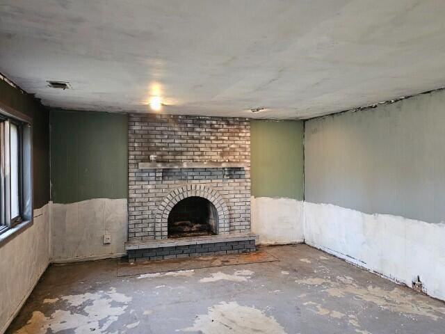 unfurnished living room with concrete floors and a fireplace