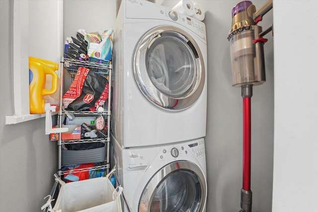 clothes washing area with stacked washing maching and dryer