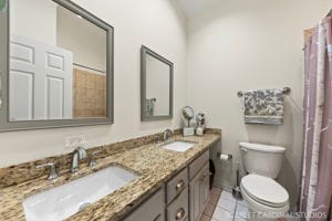 bathroom featuring tile patterned flooring, vanity, and toilet