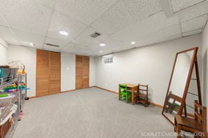 game room with a paneled ceiling and carpet flooring