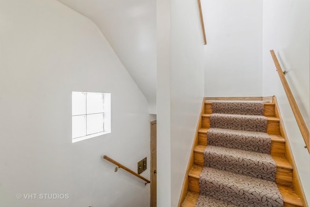 stairway with lofted ceiling and wood-type flooring