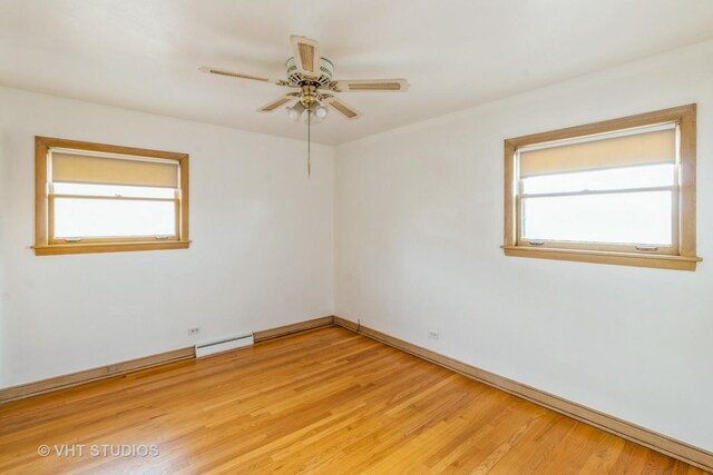 empty room with a baseboard heating unit, light hardwood / wood-style floors, and ceiling fan