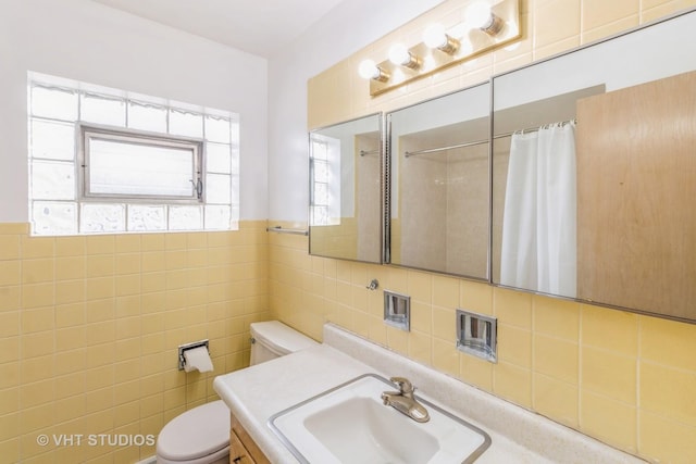 bathroom featuring vanity, a shower with curtain, tile walls, and toilet