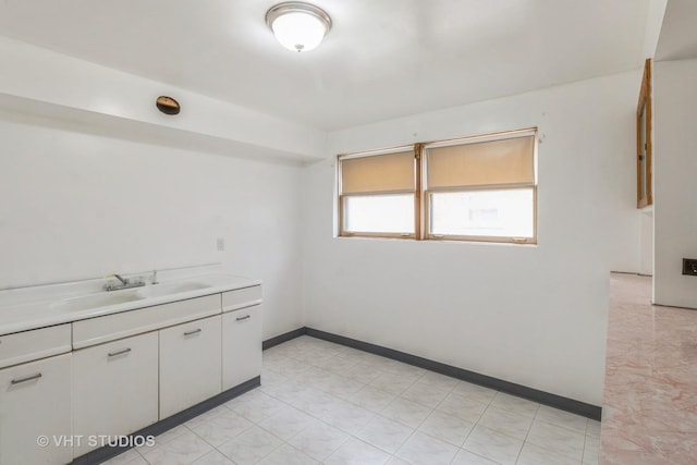 interior space with white cabinetry and sink