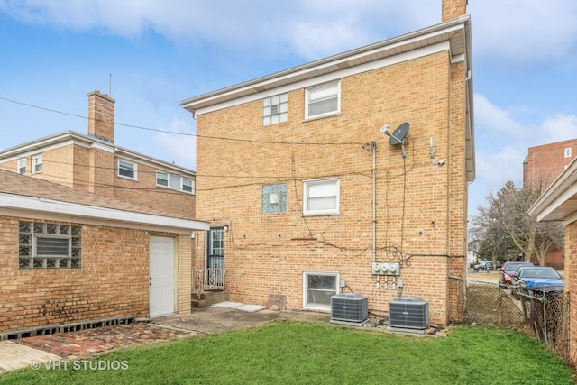 rear view of house with a yard and cooling unit