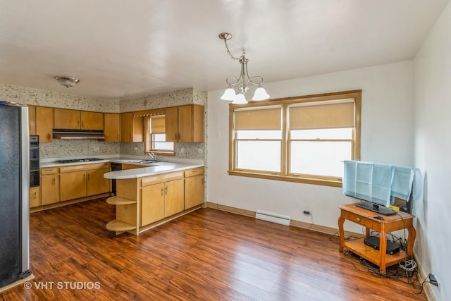 kitchen featuring pendant lighting, sink, a chandelier, gas stovetop, and dark wood-type flooring