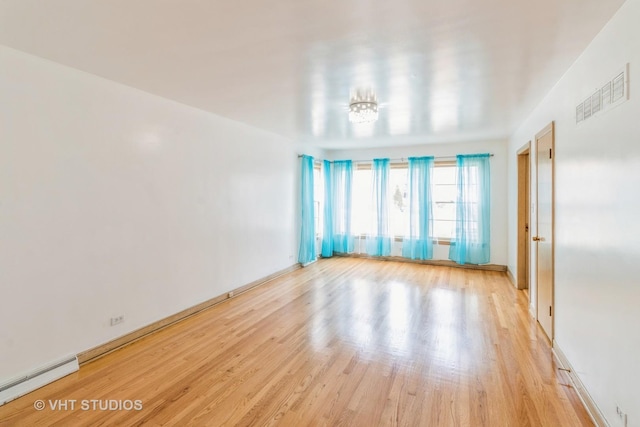 spare room with a baseboard radiator and light hardwood / wood-style flooring