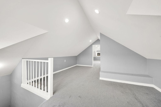 additional living space featuring carpet flooring and vaulted ceiling