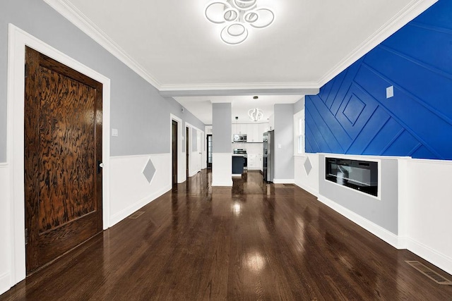 unfurnished living room featuring ornamental molding and dark hardwood / wood-style floors