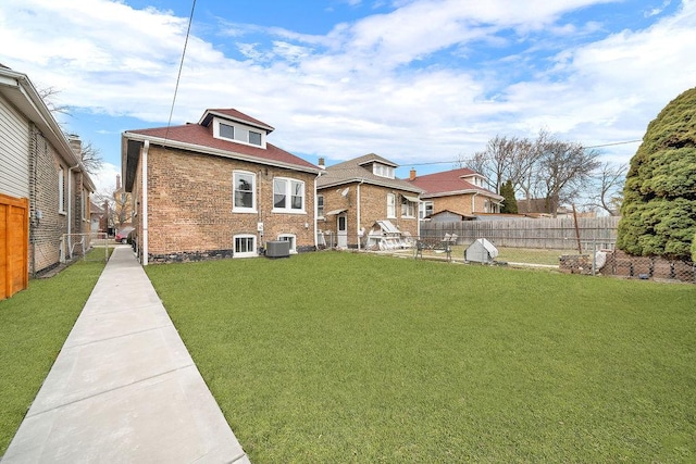 back of house with central air condition unit and a lawn