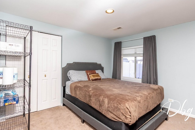 bedroom with a closet, carpet flooring, visible vents, and baseboards