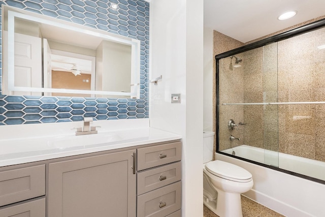 full bathroom featuring tasteful backsplash, vanity, shower / bath combination with glass door, and toilet