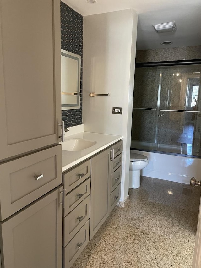 full bathroom with toilet, vanity, and shower / bath combination with glass door