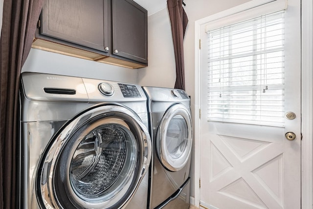 washroom with cabinets and washer and dryer