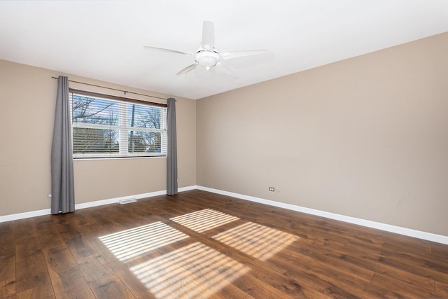 empty room featuring dark wood-type flooring and ceiling fan