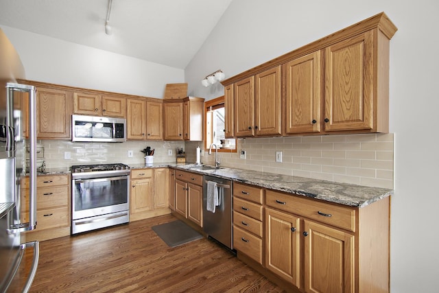 kitchen with dark hardwood / wood-style floors, sink, backsplash, dark stone counters, and stainless steel appliances