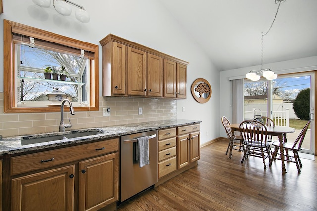 kitchen with dishwasher, lofted ceiling, sink, dark stone countertops, and dark hardwood / wood-style flooring